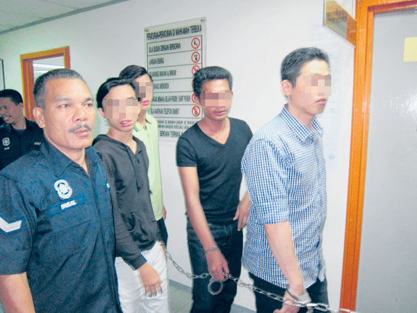 ANGGOTA polis mengiringi suspek (dua dari kanan) selepas prosiding mendapatkan perintah reman di Mahkamah Sesyen Ampang Jaya semalam.