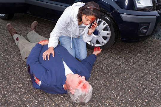 Wounded woman calling for an ambulance after a car accident