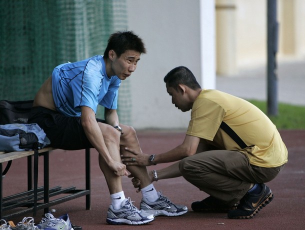 Malaysia's badminton shuttler Lee Chong Wei (L) gets a massage from coach Misbun Sidek during a physical training in Kuala Lumpur July 24, 2008. Lee holds one of Malaysia's best shots at a gold medal since the country first sent athletes to the Olympics 52 years ago, but the badminton shuttler says pressure is not a problem -- yet. With two weeks to go before the Beijing Games begin, the world No. 2 told Reuters hard-core physical training had ended and he was now getting mentally prepared to face the best badminton players in the world. REUTERS/Zainal Abd Halim (MALAYSIA)